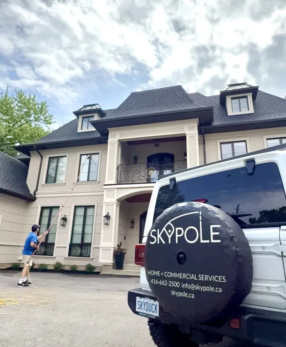 Skypole technician cleaning windows from the ground with a water-fed pole