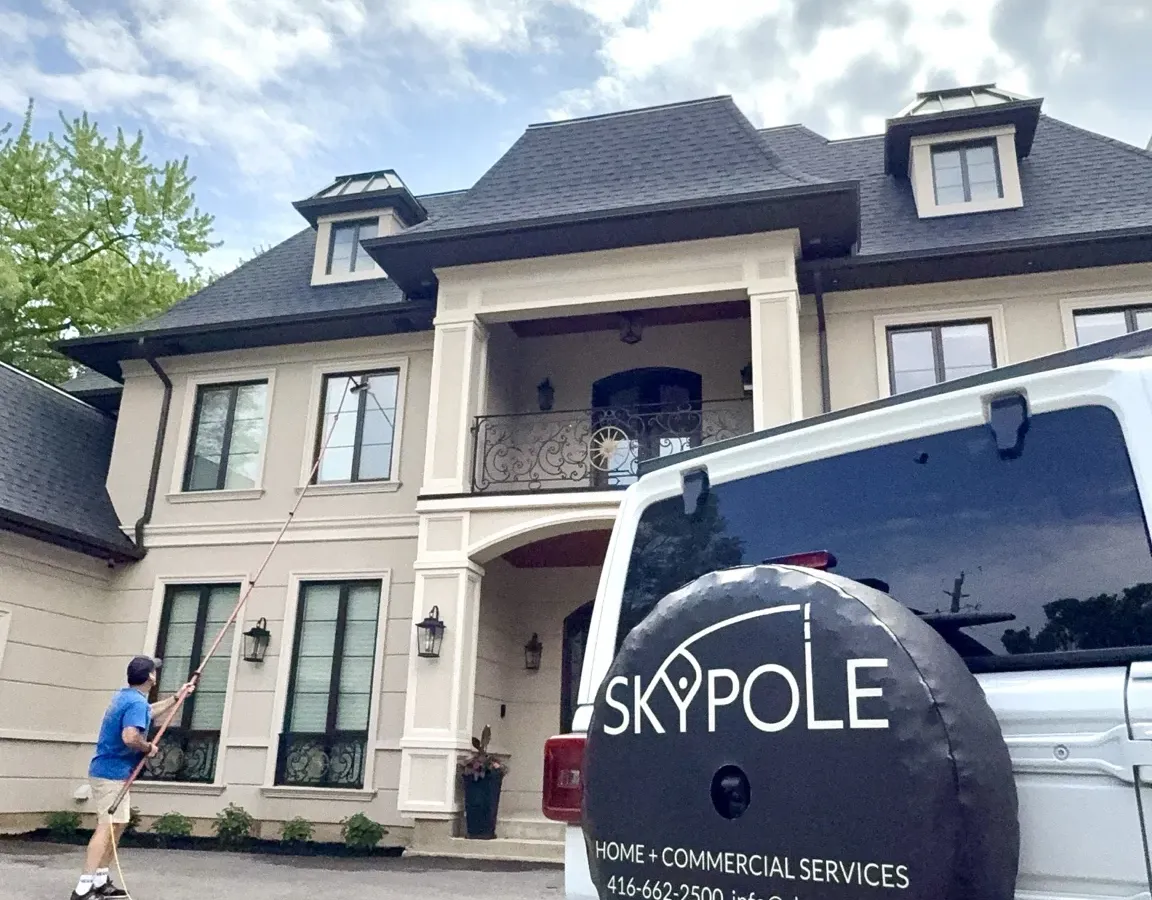 SKYPOLE technician cleaning upper-level windows of a luxury Toronto home using a water-fed pole system.