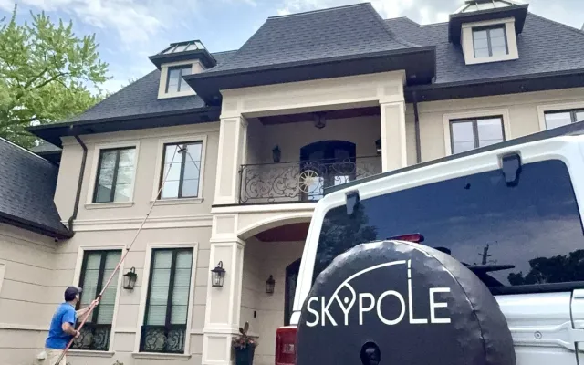 SKYPOLE technician cleaning upper-level windows of a luxury Toronto home using a water-fed pole system.