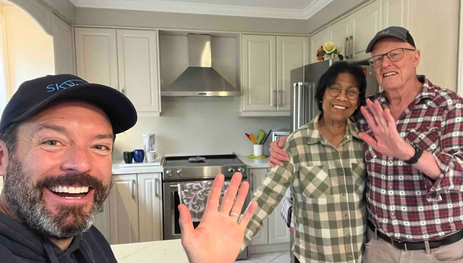 Three people smiling in a bright kitchen in Brampton
