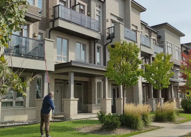Man cleaning windows on modern residential town homes
