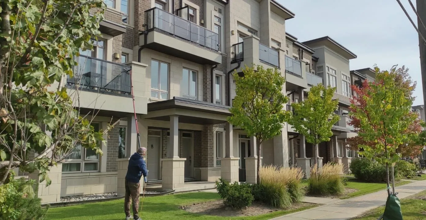 Man cleaning windows on modern residential town homes