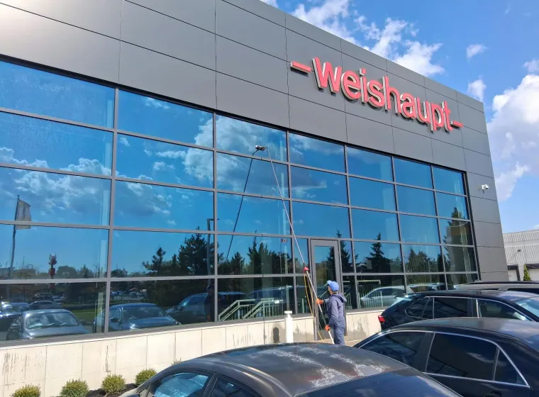SKYPOLE technician using a water-fed pole to clean exterior windows at Weishaupt Corporation headquarters in Mississauga.
