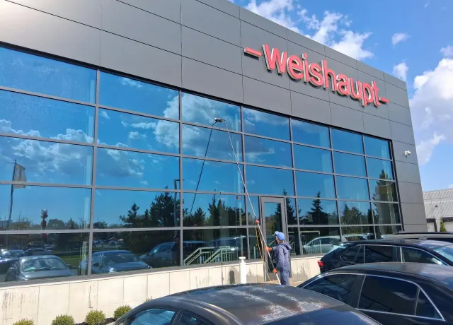 SKYPOLE technician using a water-fed pole to clean exterior windows at Weishaupt Corporation headquarters in Mississauga.