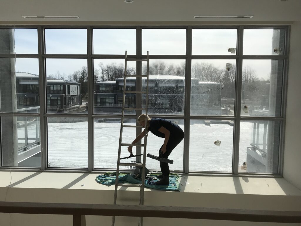 Person cleaning windows in snow-covered building