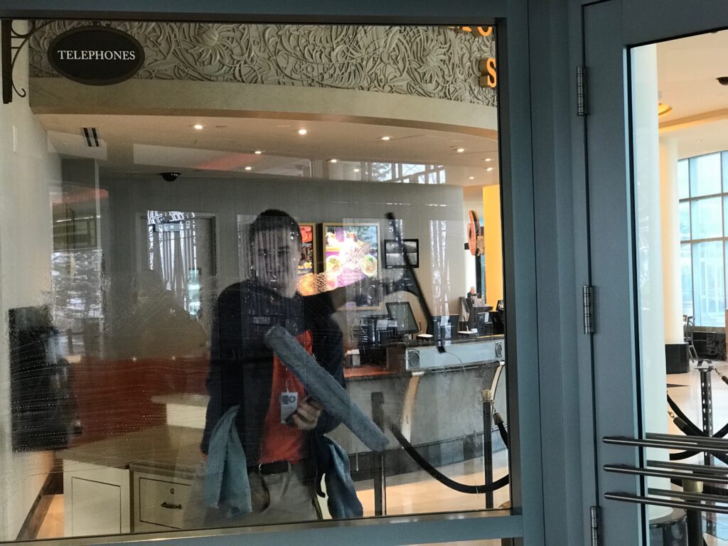 Man reflected in window at modern hotel lobby