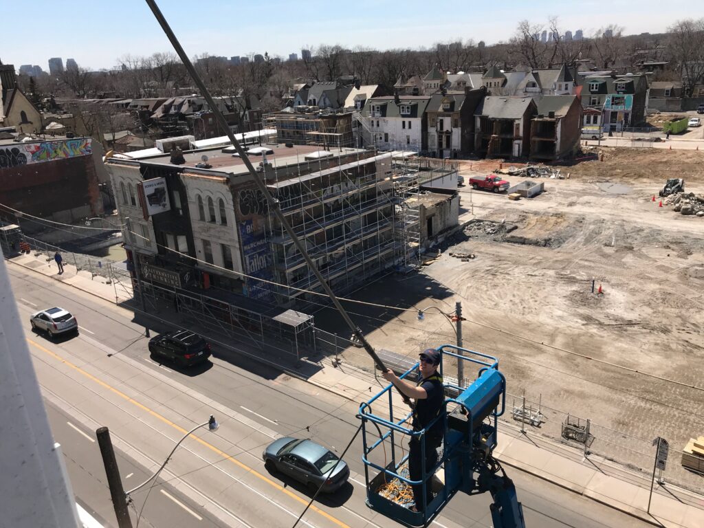 Urban construction site with worker in elevated platform