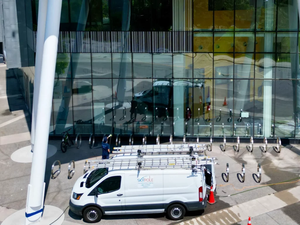 Van parked outside modern glass building.