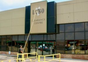 Cleaning a sign and windows at an LCBO in Toronto