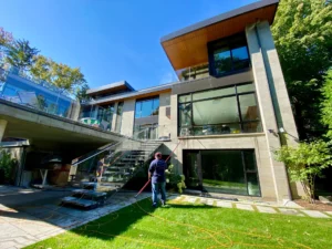 Modern house exterior with man washing windows.