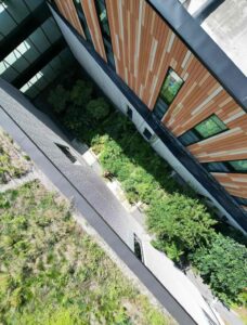 Aerial view of modern building with green courtyard.