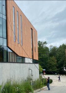 Man cleaning building windows, modern architecture.