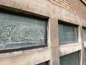 Soapy window with unique circular patterns on building