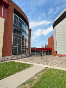 Person walking by modern red and glass building