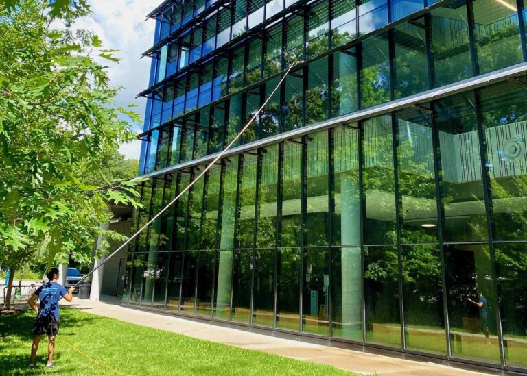 Man cleaning large glass facade of modern building