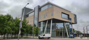 Modern building exterior with worker on lift cleaning windows