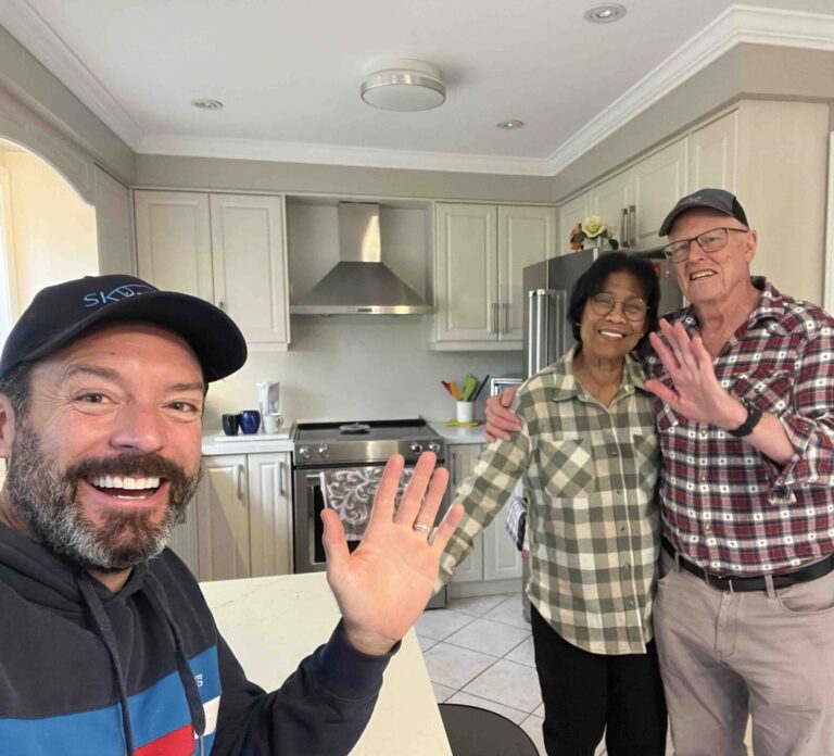 Three people smiling in a bright kitchen in Brampton