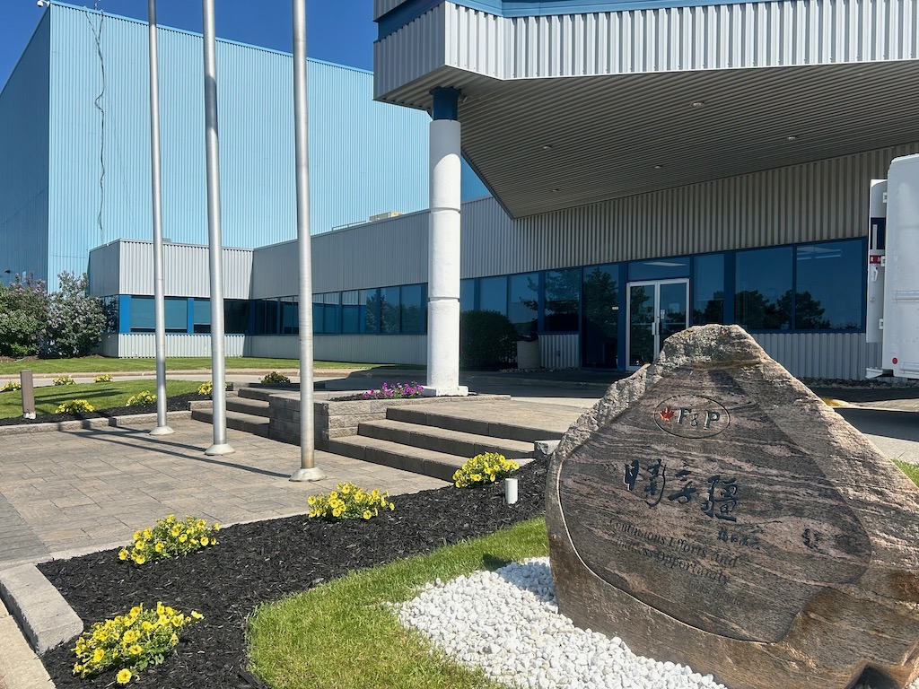 Industrial building entrance with landscaped garden and signage rock
