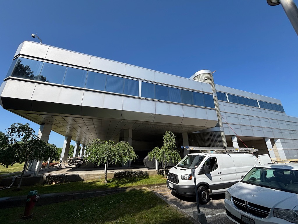 Modern elevated building with parked vehicles underneath