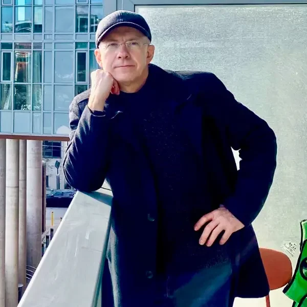 Man leaning on railing in urban setting.