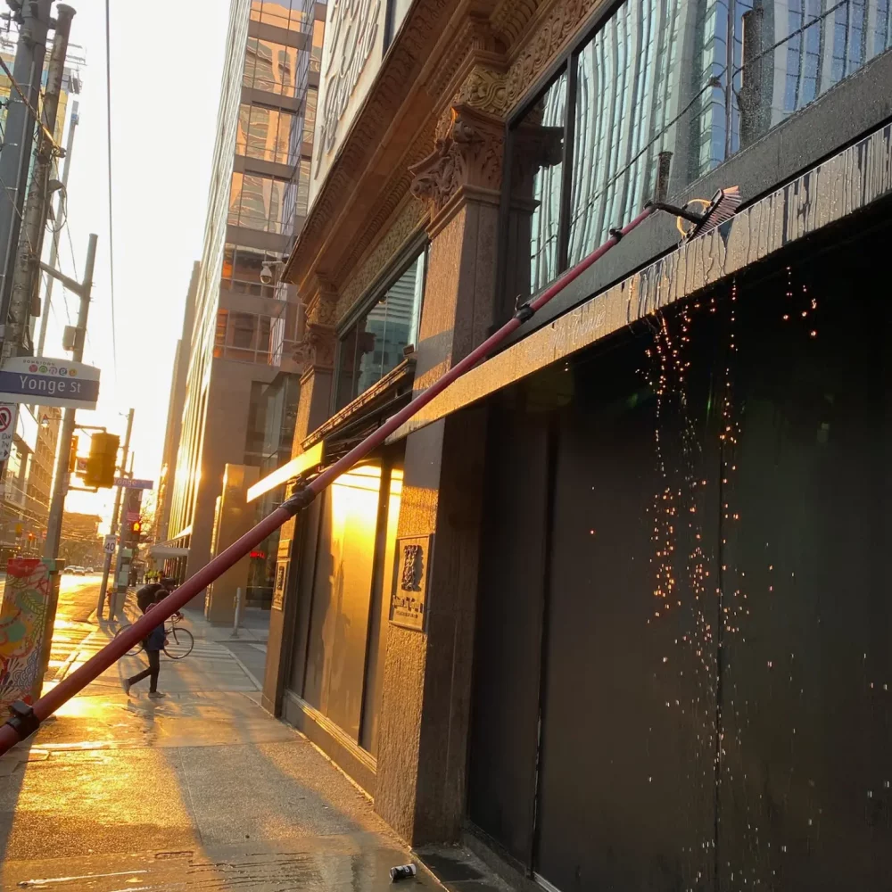 Sunset reflecting on urban street with water sparks.